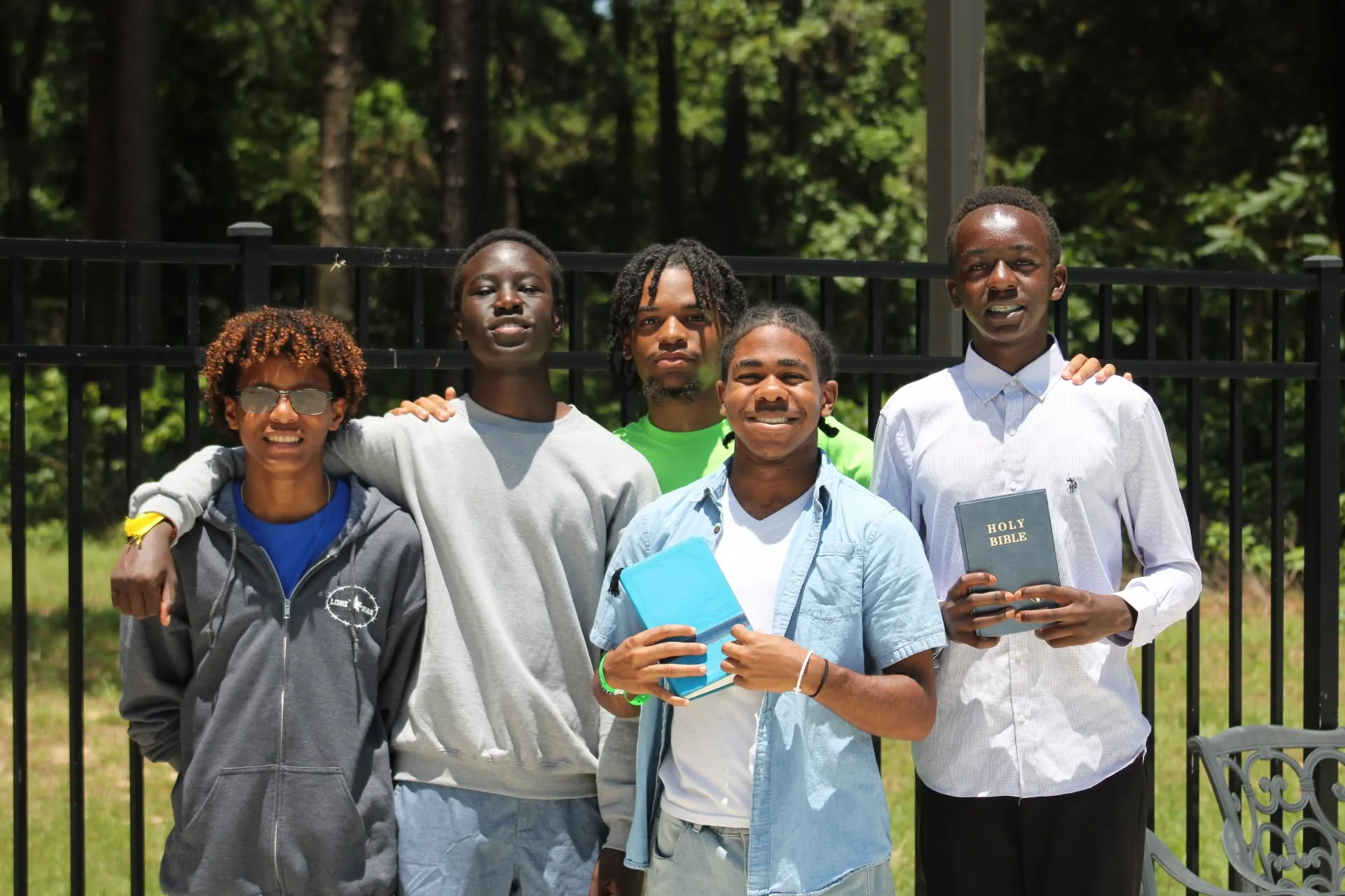 Young men holding Bibles after baptism